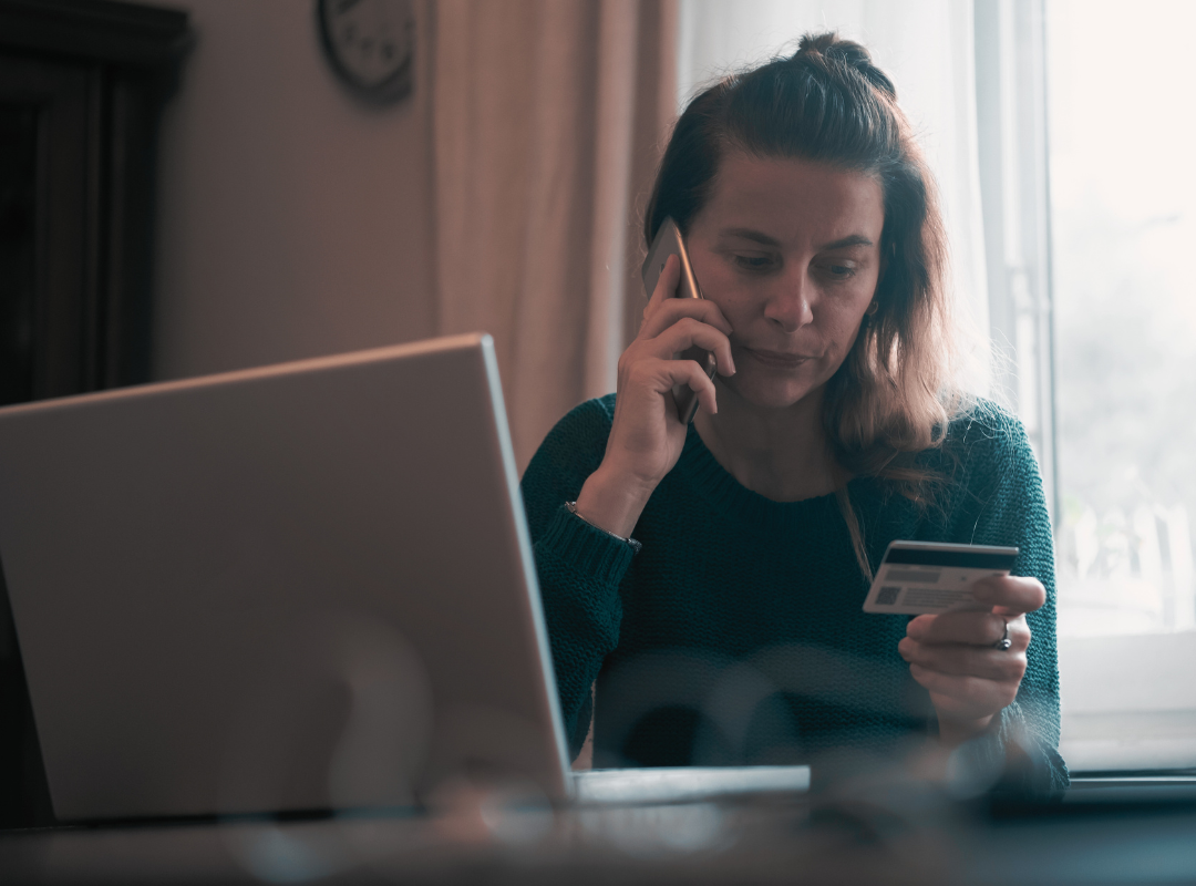 Cash House Buyer Scam - lady with bank card on the phone